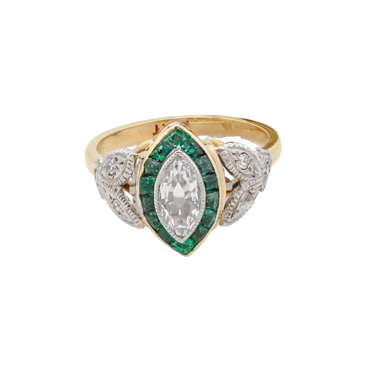 Marquise diamond and calibré emerald halo ring in 18k yellow gold and platinum with engraved shoulders.